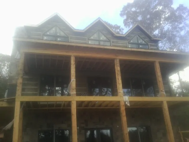 Dormers and porch framing on a large log home under construction — Roof Coating work by our crew in Elk Falls